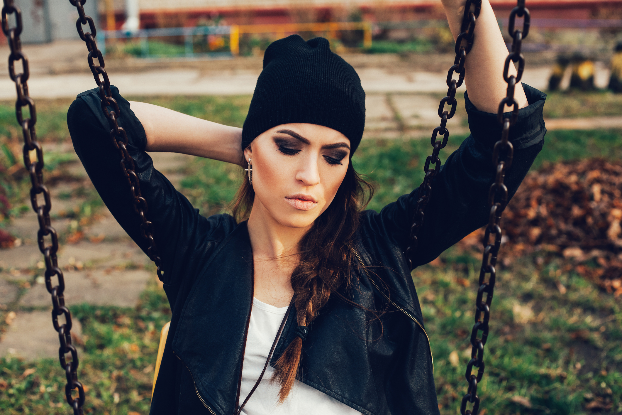 Portrait of a beautiful girl hipster on a swing