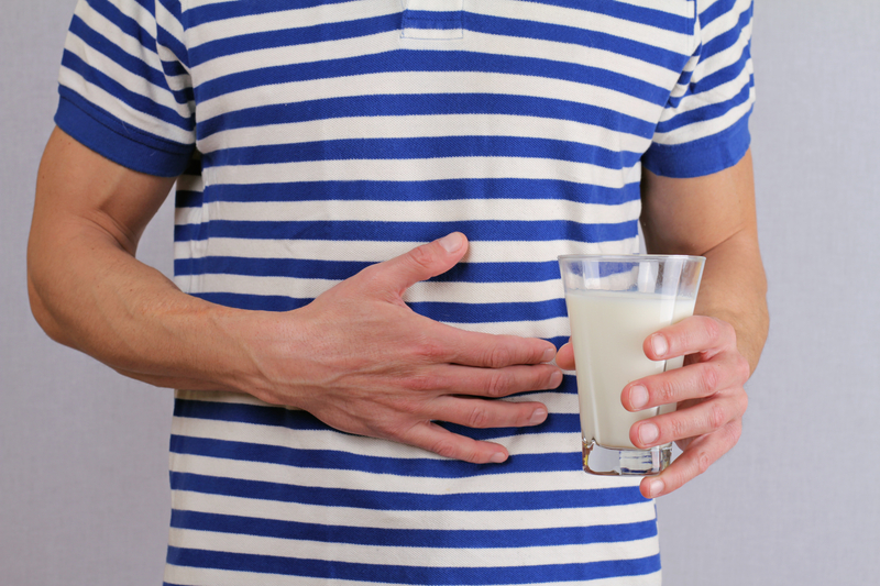 Man with stomach pain holding a glass of milk. Dairy Intolerant person. Lactose intolerance, health care concept. | © Albina Glisic | Dreamstime Stock Photos